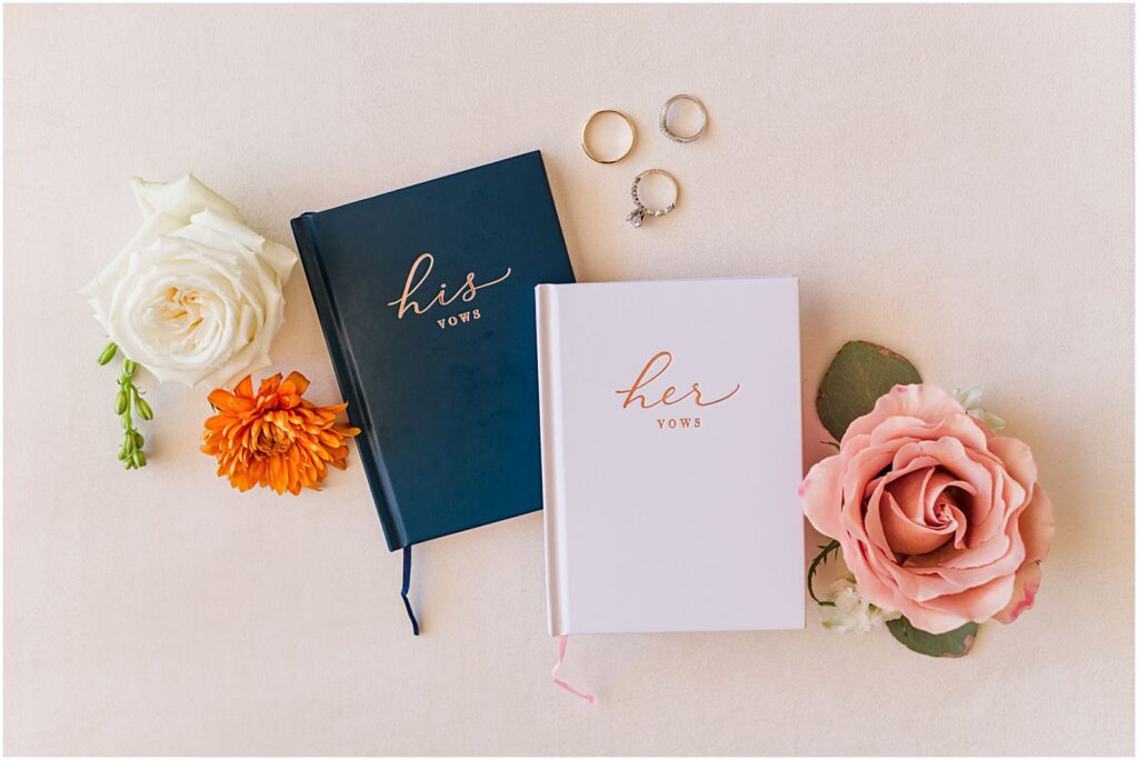 his and her vow books with flowers