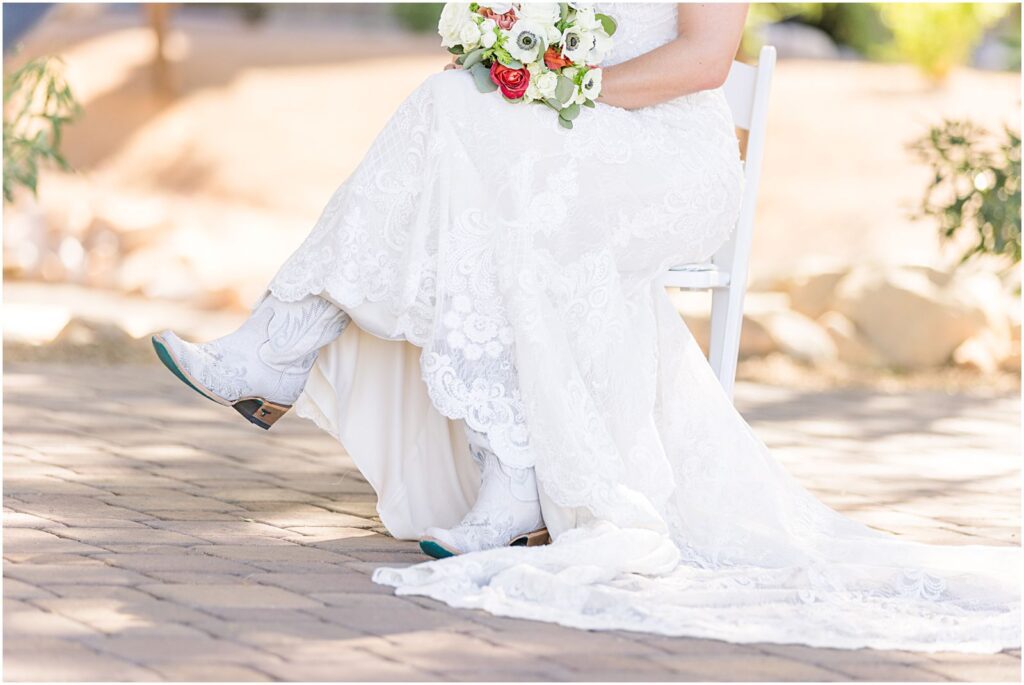 bride sitting in chair wearing white cowboy boots