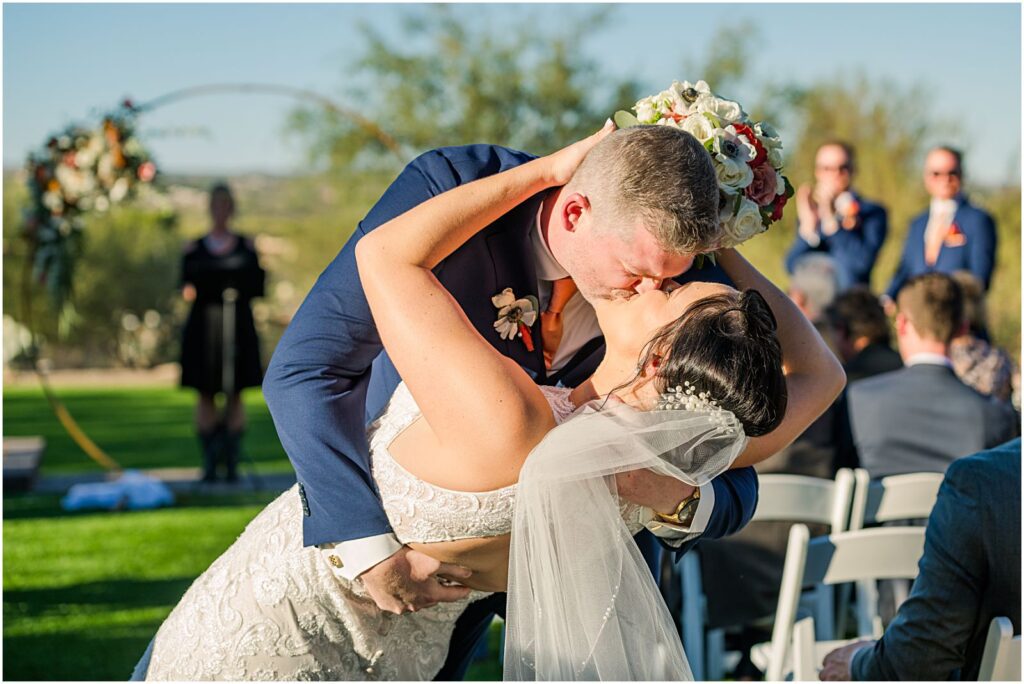 big dip kiss in aisle after wedding ceremony ends