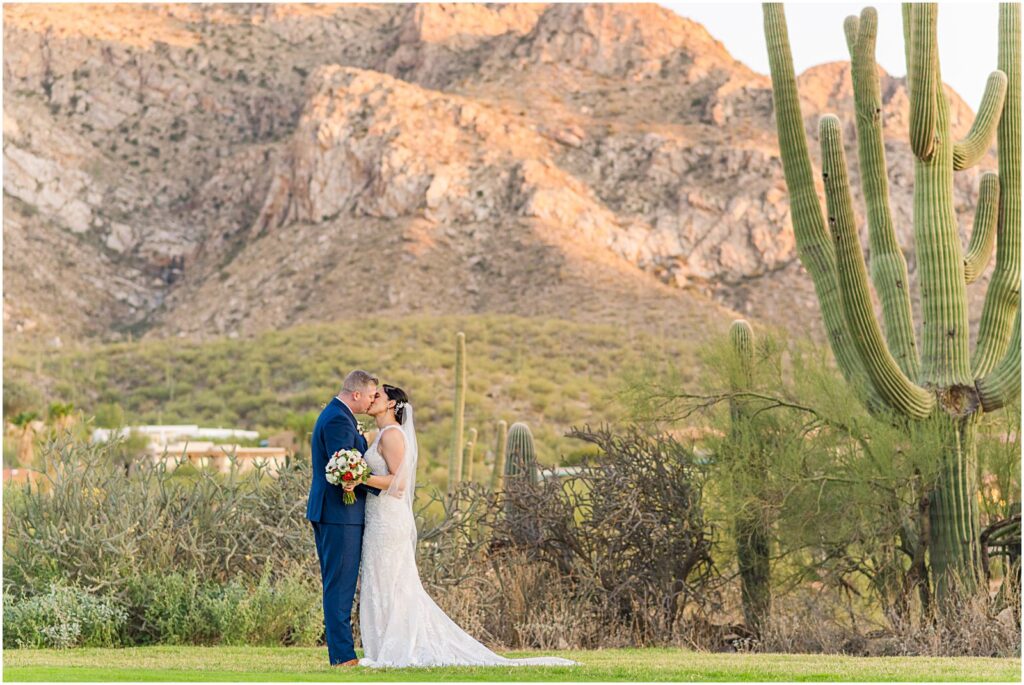 couple kissing in desert with big mountains behind them