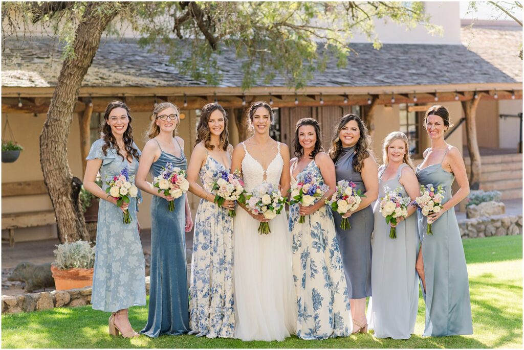 bride with her bridesmaids on green lawn at ranch wedding