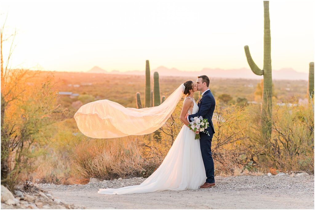 bride and groom kissing at sunset in desert at Tanque Verde Ranch wedding